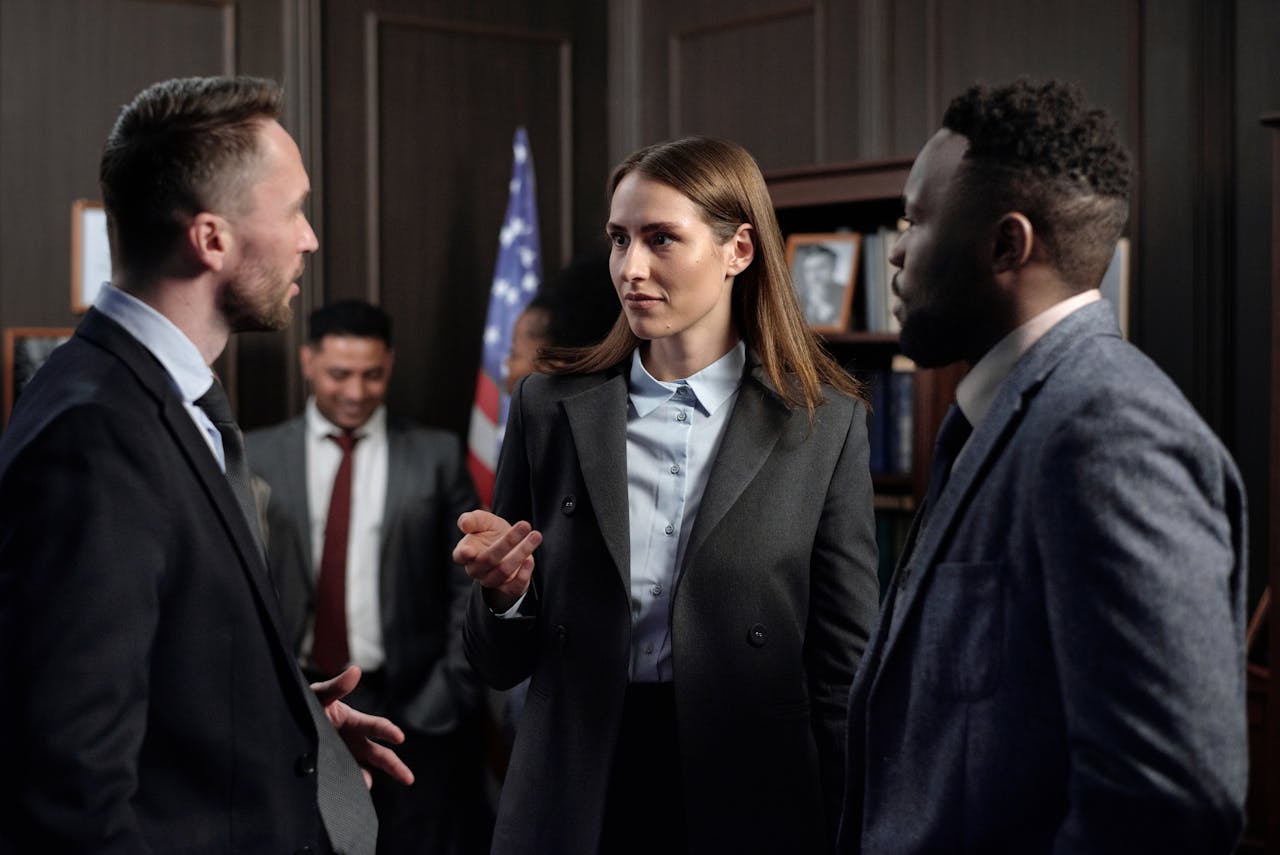 A diverse group of business professionals engaged in a discussion in an office.