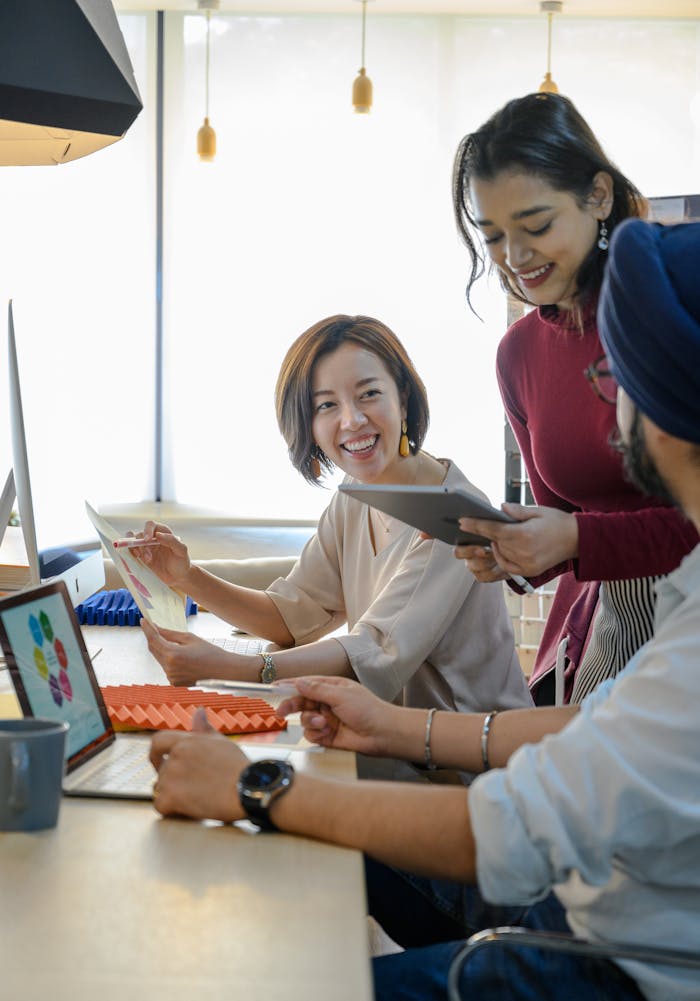 A diverse group of coworkers engaging in a creative discussion at a modern office desk.